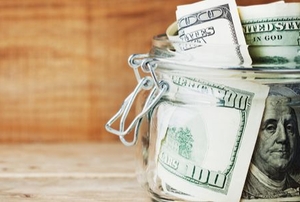a savings jar with hundred dollar bills