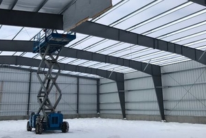 A pre-engineered metal building with an automated construction lift inside
