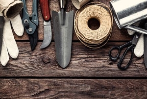 Various garden tools laid out on a wooden table.