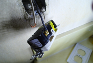 outlet dangling from the wall