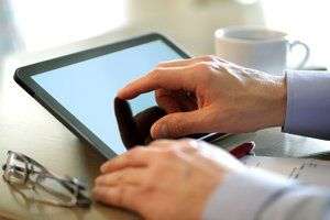 Image of hands using a touch screen tablet.