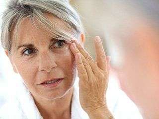 Image of a concerned woman touching her eye.