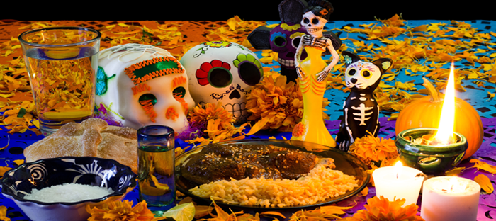 Mexican Day of the Dead table with food and sugar skull figurines
