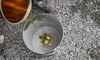amber liquid being poured into a silver cup