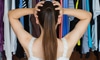 A girl holds her head while looking at a closet stuffed with hanging clothes