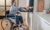 woman in wheelchair using accessible wall-mounted oven