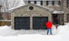 A homeowner shovels snow from his driveway. 