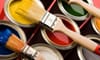 Variety of open paint cans and brushes