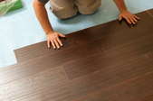 Snap-together laminate wood flooring covering a concrete subfloor.