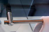 Looking down on a stainless-steel towel rack with the edge of a towel visible on the right side of the frame.