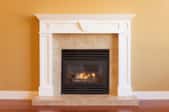 An elegant gas fireplace set into a wall with a marble hearth.