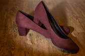 A pair of wine-colored, suede high heels.