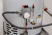 The controls of a hot water heater on a metal platform.