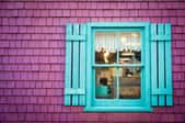 teal window frame and board and batten shutters