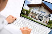 person looking at house on laptop