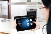 A woman accessing her tablet in her smart kitchen.