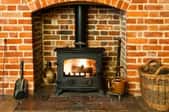 fire burning in wood stove surrounding by brick