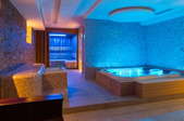 indoor spa and hot tub with colorful lighting