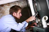 A man adjusts a furnace.