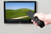 Pointing a remote at a wall-mounted flat screen TV
