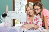 girl watching a woman sew