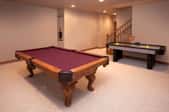 A rec room with a pool and air hockey table.