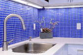 kitchen with blue tile backsplash and large stainless steel sink