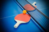 paddle and ball laying near net on ping pong table