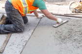 A man works on concrete.