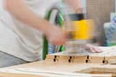 A woodworker using a router to cut MDF.