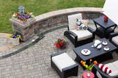 An outdoor seating area and a sitting wall on a paved patio. 