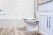 bathroom with white fixtures and tan flooring