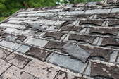 A roof with shingles coming off. 