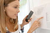 A woman programs her security system.