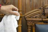 Wiping an antique chair with a white cloth