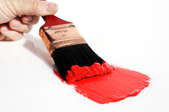 A paint brush is used to paint a streak of red.