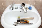 A sink full of plumbing tools.