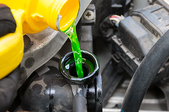 Pouring coolant into the tank of a car