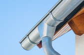 the corner of a seamless metal gutter with supporting brackets