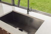 kitchen sink and counter next to window onto lawn