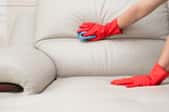 Someone cleaning white couch cushions. 