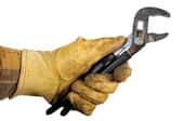 A hand in work gloves holding black-handled pliers.