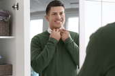 man getting dressed with closet door mirror