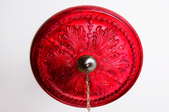 A bright, red ceiling medallion with a chandelier hanging from it.