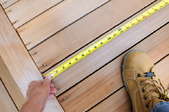 Measuring the lumber used for a wood balcony.