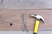 A hammer and nails standing by for a paneling project.
