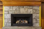 A stone fireplace with an insert.