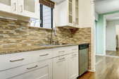 kitchen with white cabinets, tile backsplash, and wood floors