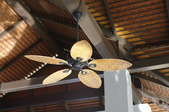 ceiling fan mounted to a beam on a high ceiling