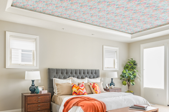 A bedroom with a wallpaper statement ceiling